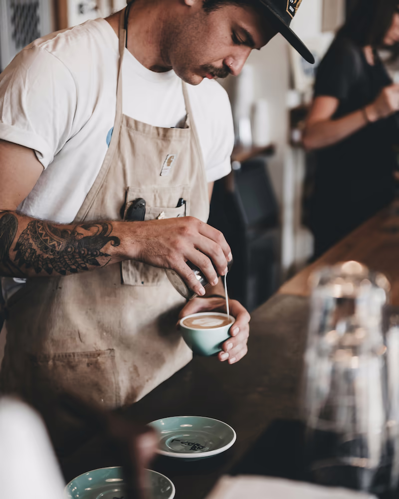 Male barista making coffee for a customer order.